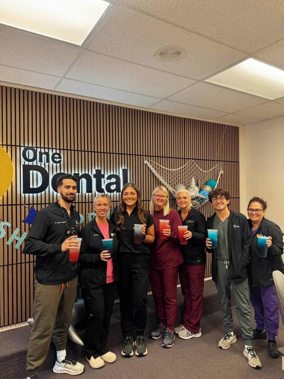 The One Dental team smiling with their color-changing teas after a Flourish delivery
