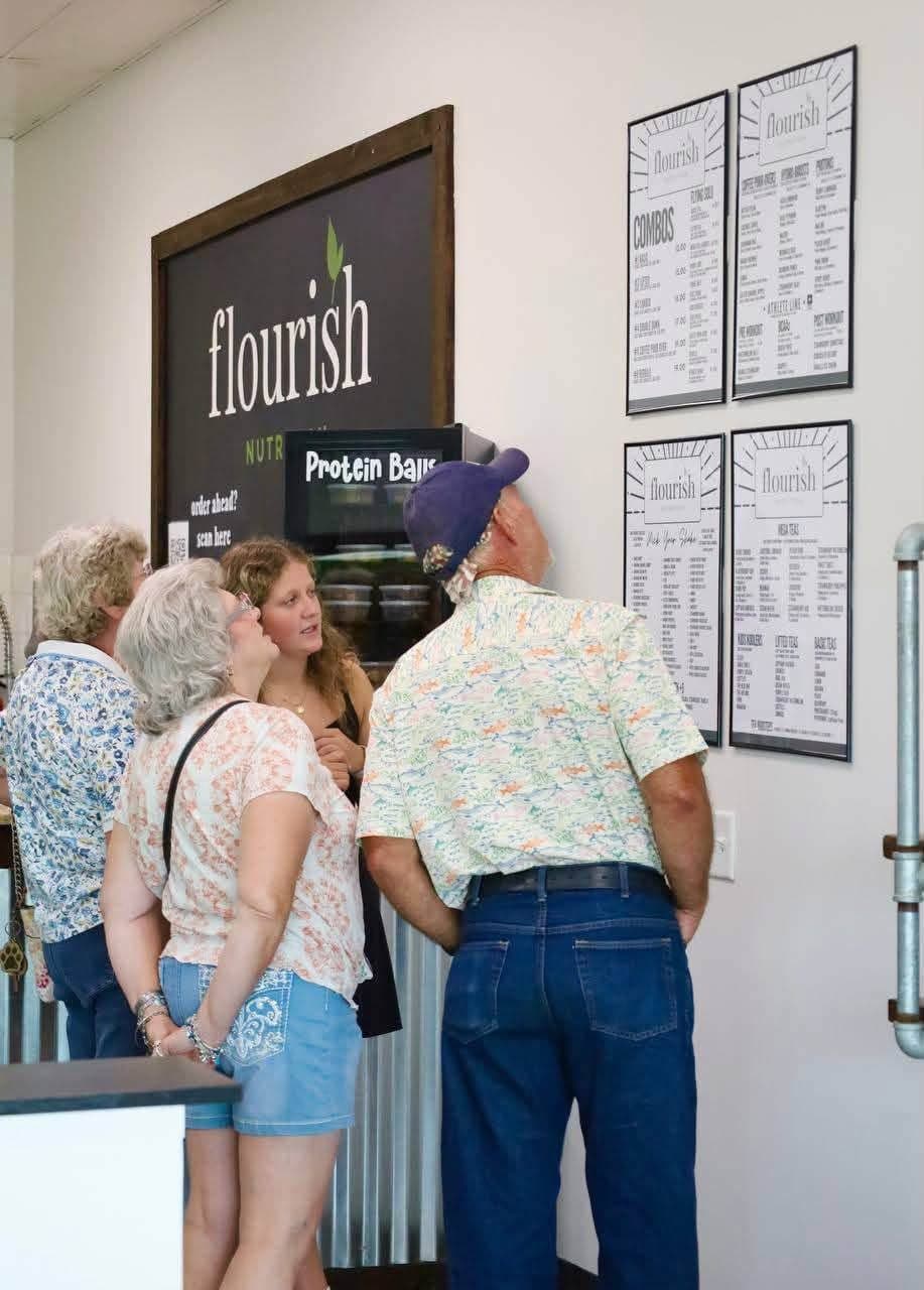 Guests reading the Flourish Nutrition menu boards inside the club